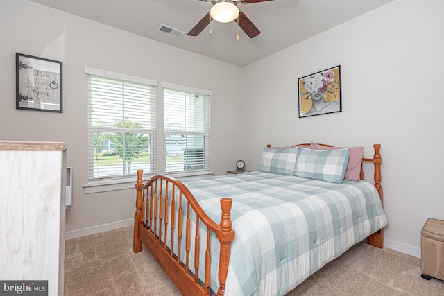 bedroom featuring ceiling fan, light carpet, and multiple windows