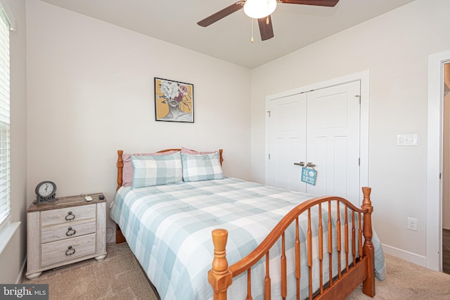 carpeted bedroom with ceiling fan and a closet