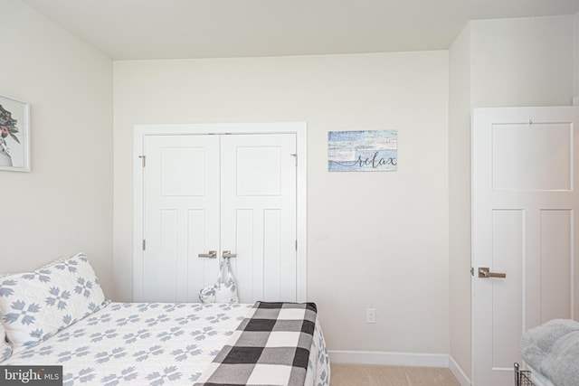 bedroom with light carpet and a closet