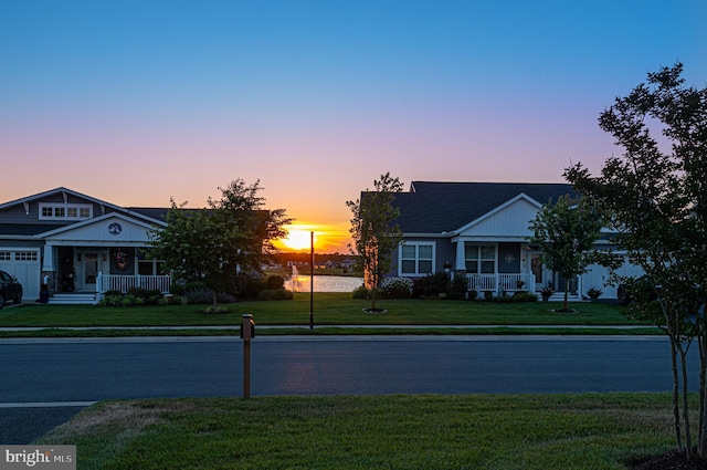 view of front of house featuring covered porch and a lawn