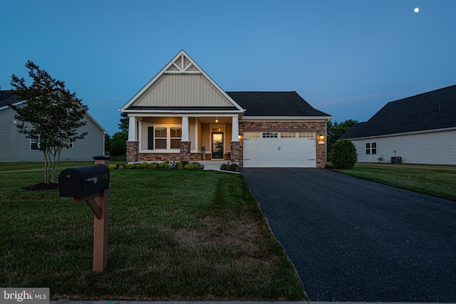 craftsman-style house featuring a porch, a garage, and a yard