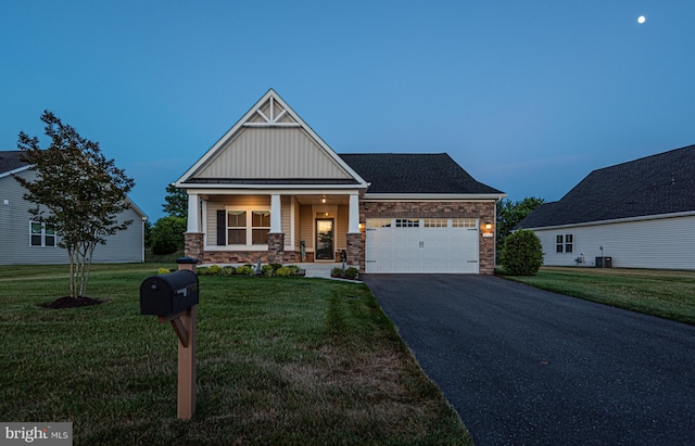 craftsman-style home with a garage, a lawn, and a porch