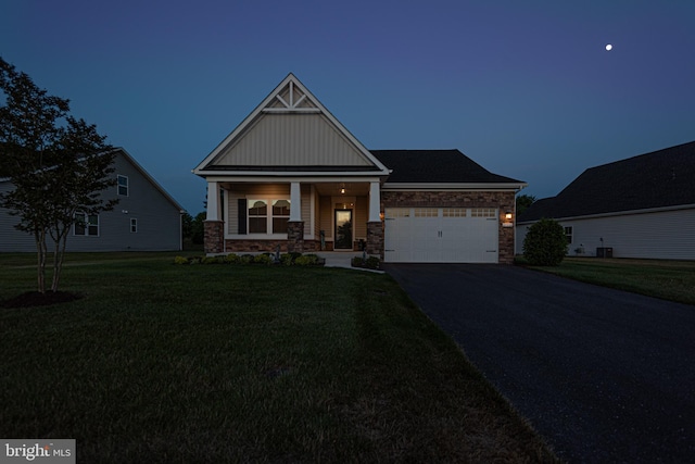 craftsman inspired home featuring a garage, a lawn, and covered porch