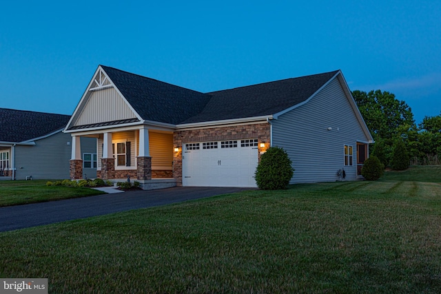 view of front facade featuring a garage, a front yard, and covered porch