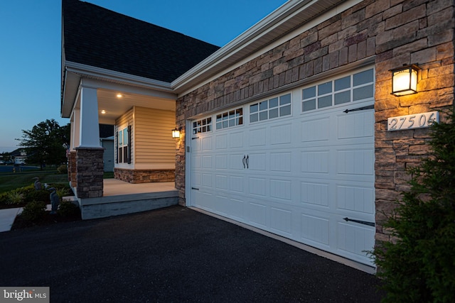 garage at dusk with covered porch