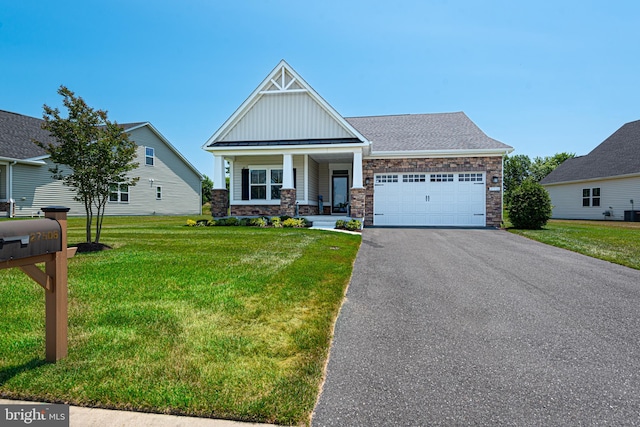 craftsman-style home with a garage, covered porch, and a front lawn