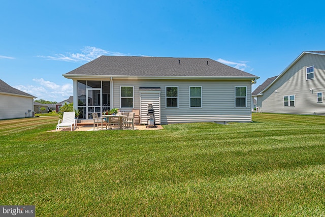 rear view of house featuring a sunroom, a patio area, and a lawn