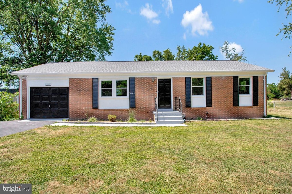 ranch-style house featuring a garage and a front yard