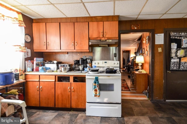 kitchen featuring a paneled ceiling, wood walls, and white range oven