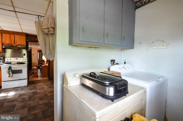 clothes washing area featuring washing machine and clothes dryer and cabinets