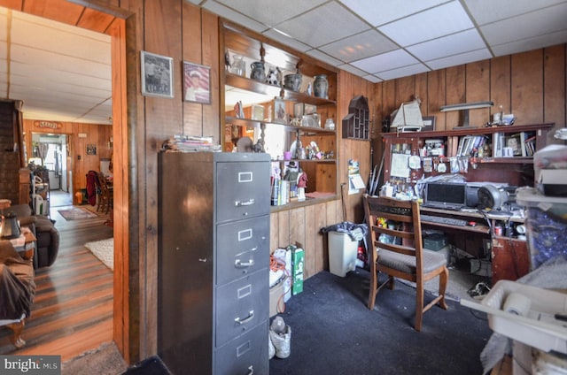 office area with wood walls, a drop ceiling, and built in features