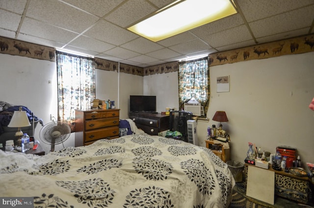 bedroom with a paneled ceiling and cooling unit