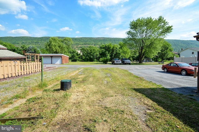 view of yard featuring a mountain view, an outbuilding, and a garage