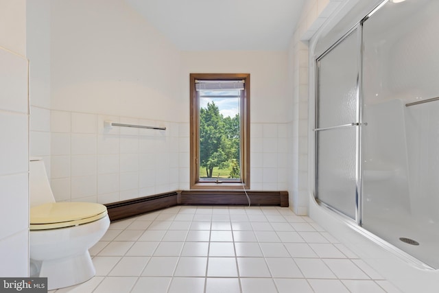 bathroom featuring tile patterned flooring, toilet, an enclosed shower, and tile walls