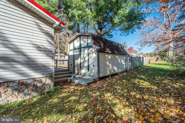 view of home's exterior featuring a wooden deck, a yard, and a storage shed