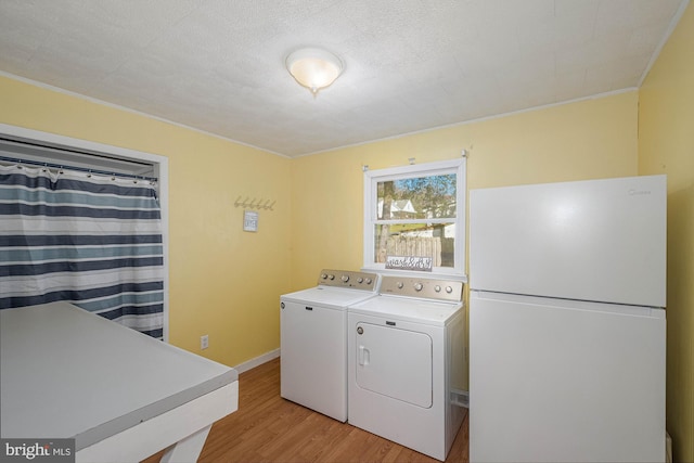 washroom featuring washer and dryer, a textured ceiling, and light hardwood / wood-style floors