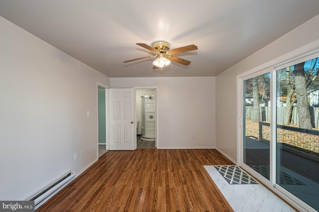 spare room featuring hardwood / wood-style flooring, ceiling fan, and a baseboard heating unit