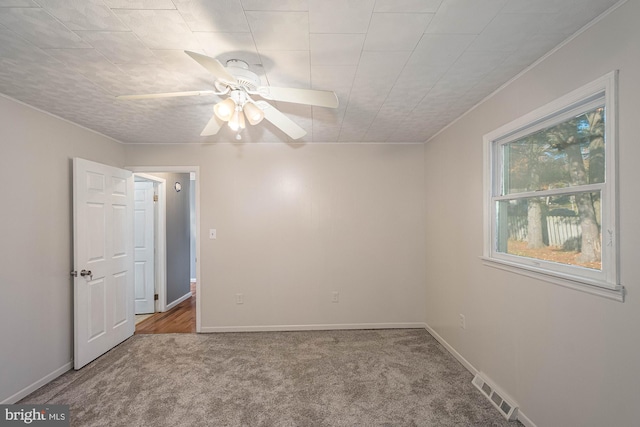 carpeted spare room with ceiling fan