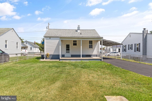 back of property with a yard, central AC unit, and a carport