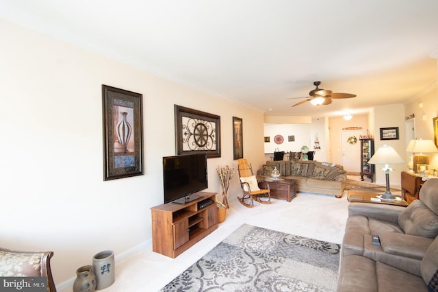 carpeted living room featuring ceiling fan and crown molding