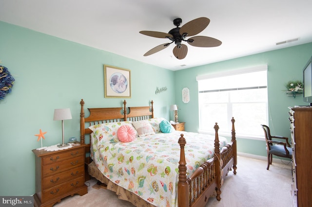 carpeted bedroom featuring multiple windows and ceiling fan