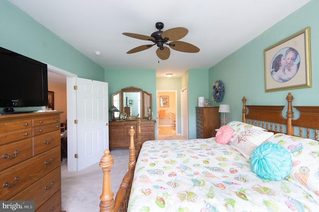 bedroom with ensuite bathroom, ceiling fan, and light colored carpet