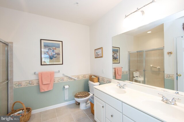 bathroom with tile patterned floors, vanity, toilet, and an enclosed shower