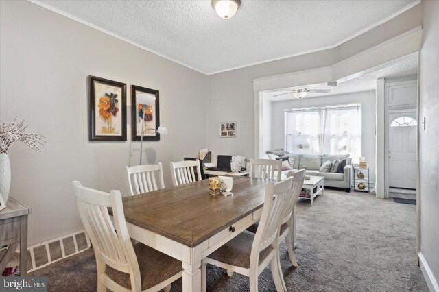 dining area with crown molding, a textured ceiling, carpet, and ceiling fan