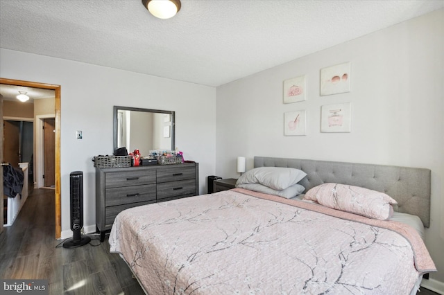 bedroom with a textured ceiling and dark wood-type flooring