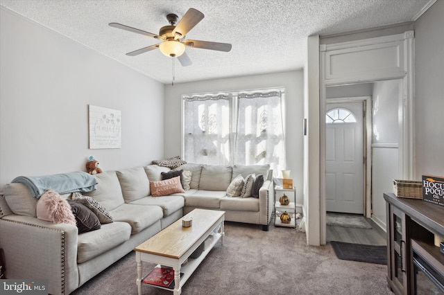 carpeted living room featuring a textured ceiling and ceiling fan