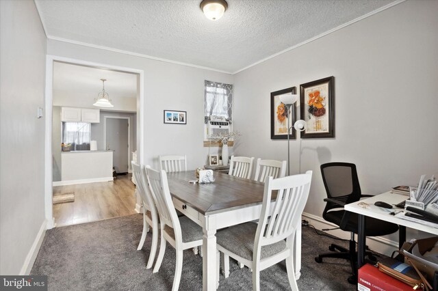 dining area featuring plenty of natural light, crown molding, a textured ceiling, and light hardwood / wood-style floors