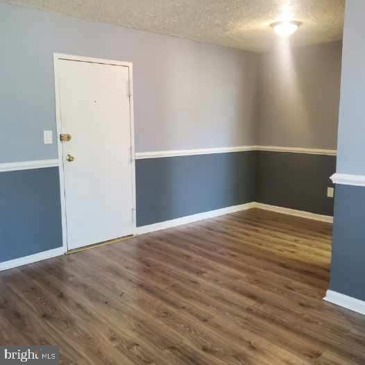 empty room featuring dark wood-type flooring and a textured ceiling