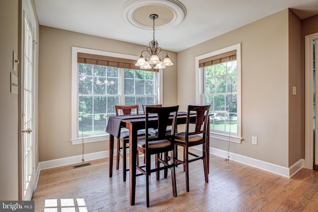 dining area featuring light hardwood / wood-style flooring and an inviting chandelier