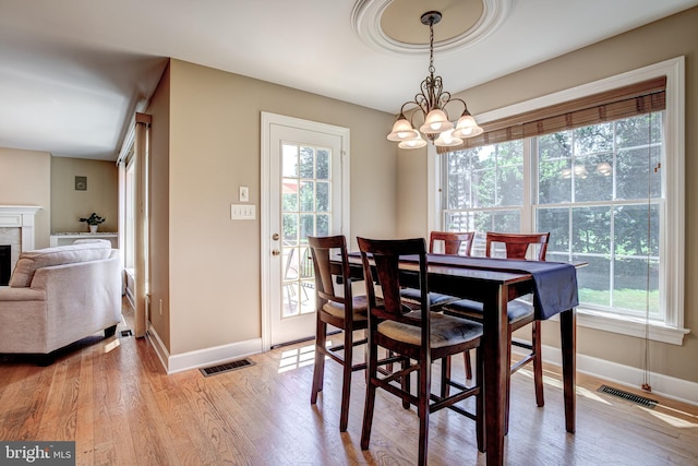 dining space with an inviting chandelier and light wood-type flooring