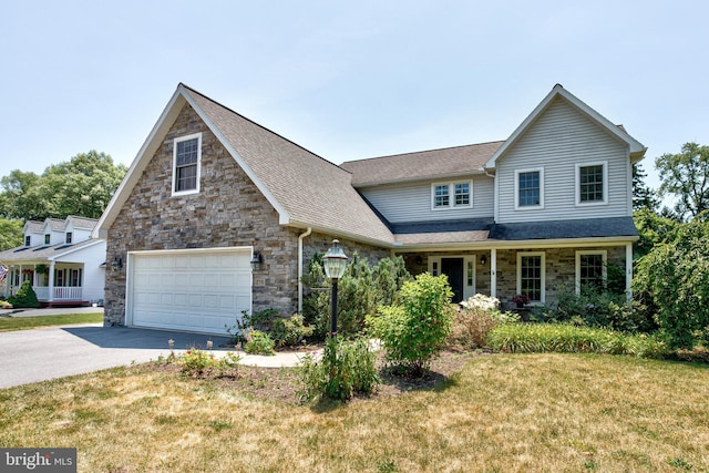 view of front of home with a front lawn, a porch, and a garage