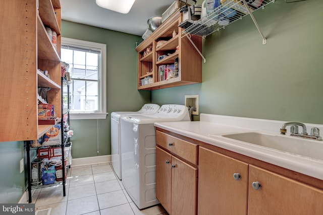 laundry area featuring cabinets, separate washer and dryer, sink, and light tile patterned floors