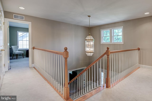 staircase with carpet and an inviting chandelier