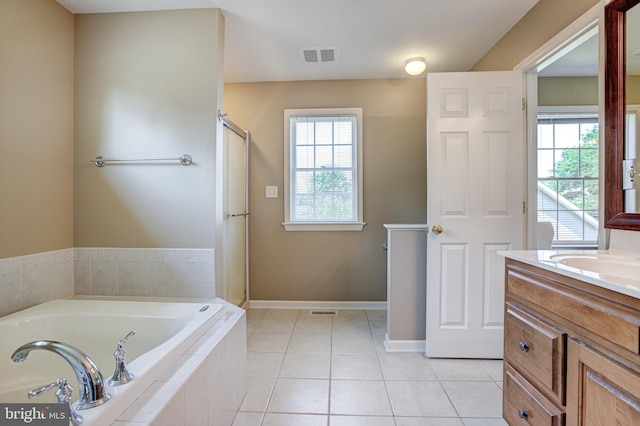 bathroom featuring tile patterned floors, vanity, shower with separate bathtub, and a wealth of natural light