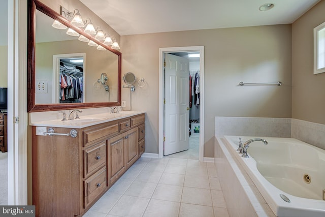 bathroom with tile patterned floors, vanity, and tiled bath