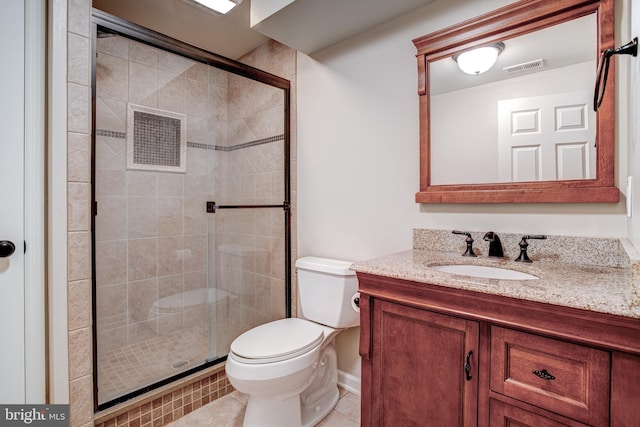 bathroom featuring toilet, vanity, tile patterned floors, and a shower with shower door