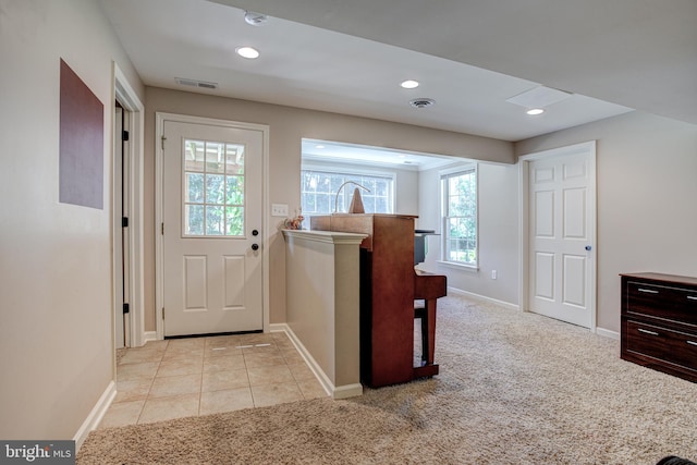 doorway to outside with light carpet