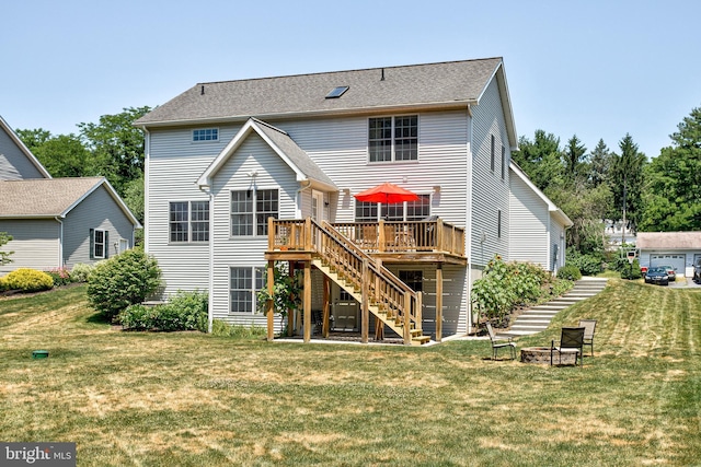 back of house with a lawn, a wooden deck, and a fire pit