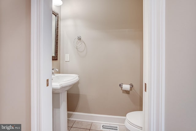 bathroom with toilet, tile patterned floors, and sink