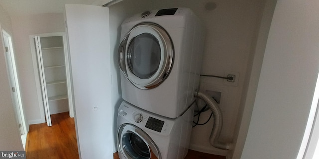 laundry room featuring light hardwood / wood-style flooring and stacked washer / drying machine