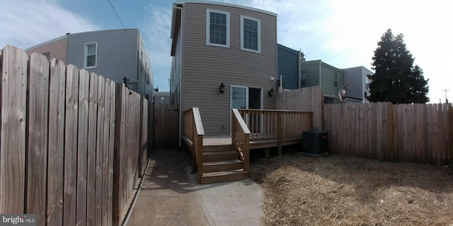 back of property with a deck and central air condition unit