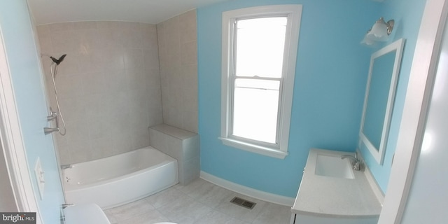 full bathroom featuring vanity, tiled shower / bath combo, and toilet