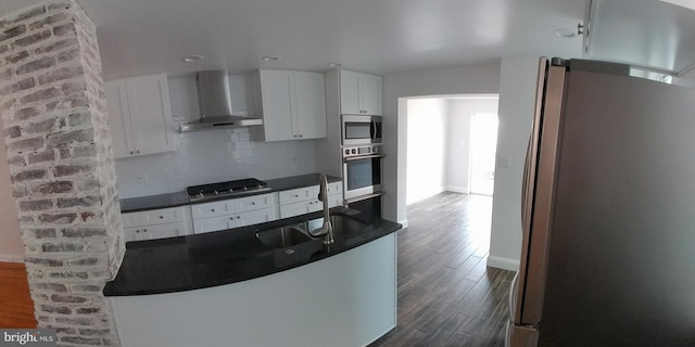 kitchen featuring sink, wall chimney exhaust hood, stainless steel appliances, backsplash, and white cabinets