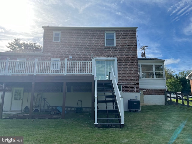 rear view of house with a lawn, a wooden deck, and central air condition unit