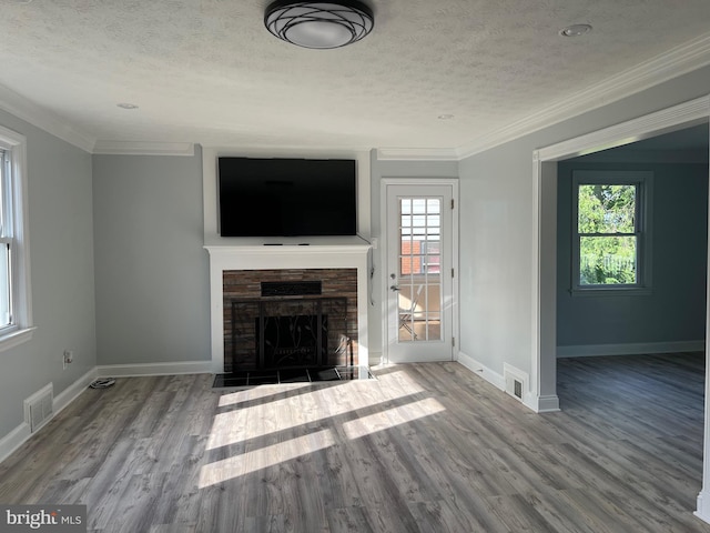 unfurnished living room with crown molding, a fireplace, hardwood / wood-style floors, and a textured ceiling