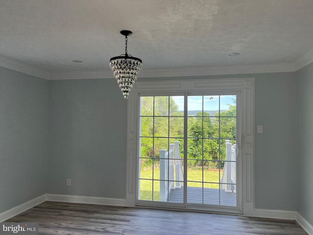 entryway with a notable chandelier, wood-type flooring, and ornamental molding